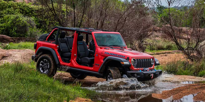 2025 Jeep Wrangler Rubicon off-roading through a stream.