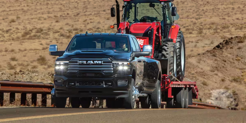 2026 RAM 3500 Heavy Duty truck towing a tractor.