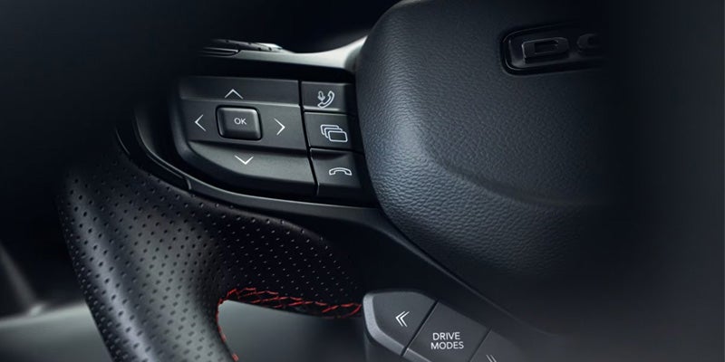 Close-up of the 2026 Dodge Charger steering wheel controls and drive mode button.