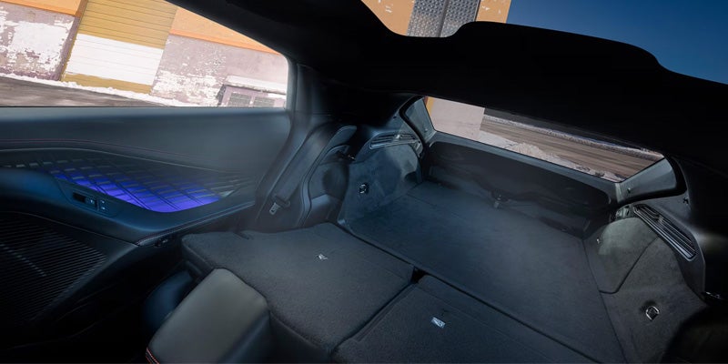Rear cargo area of the 2026 Dodge Charger with folded seats and blue ambient interior lighting.