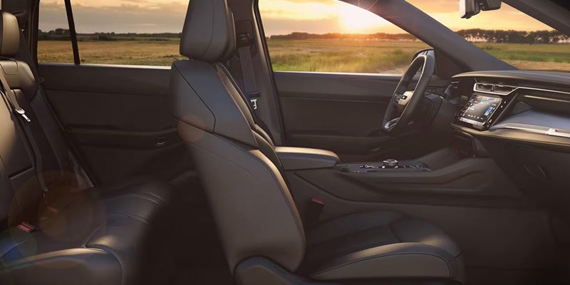 2026 Jeep Cherokee interior showing black front seats, dashboard controls, and a sunset view through the windows.