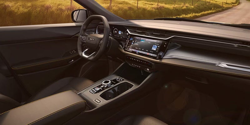 2026 Jeep Cherokee interior with a wide dashboard display, steering wheel, and center console controls.