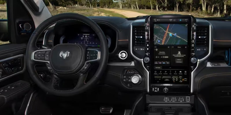 2026 RAM 1500 interior showcasing a premium dashboard with a large touchscreen and advanced driver controls.